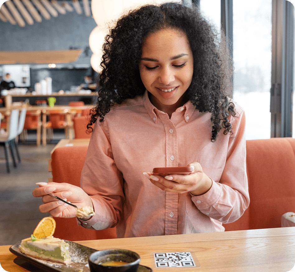 Customer using phone with QR code at cafe